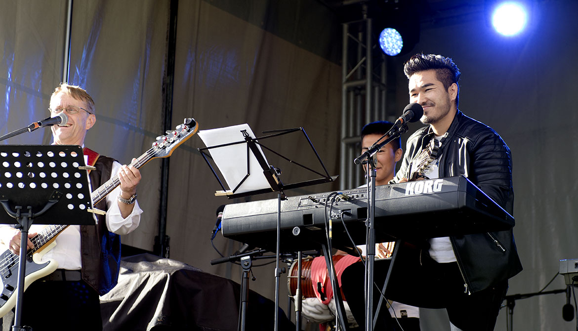 Tre män spelar musik på en scen